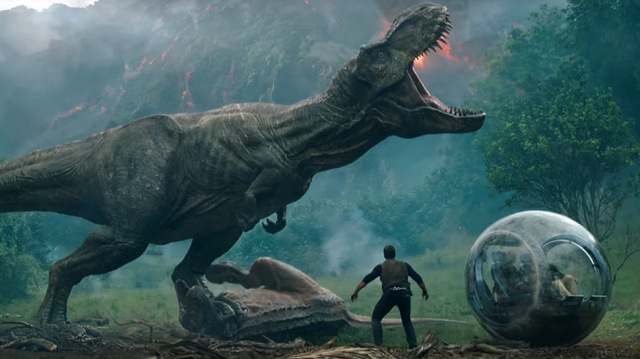 T-Rex ruge com Carnosauro morto na frente de Owen com erupção no fundo